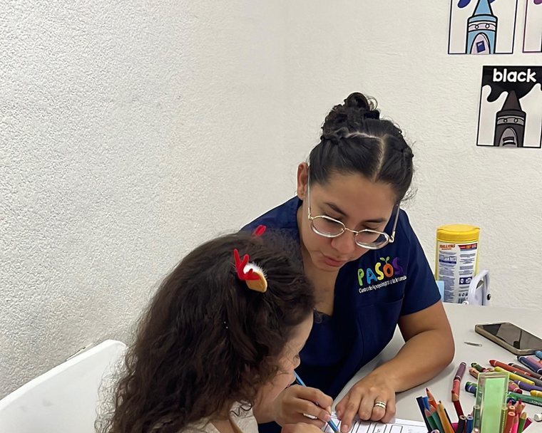 Instructora de PASOS revisando un ejercicio de vocabulario con una niña